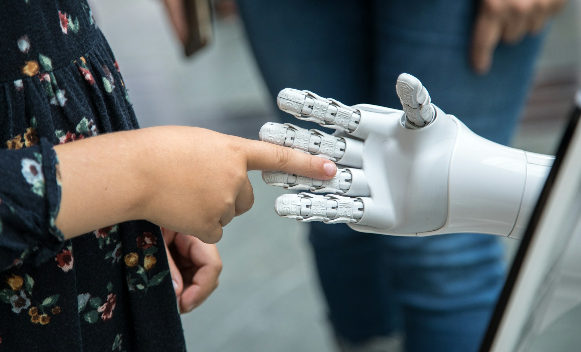 A person holding a robotic hand, human and machine in the same frame